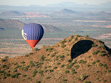 A nearby hot air balloon gets an intimate view of one of many mountains in the Phoenix area.